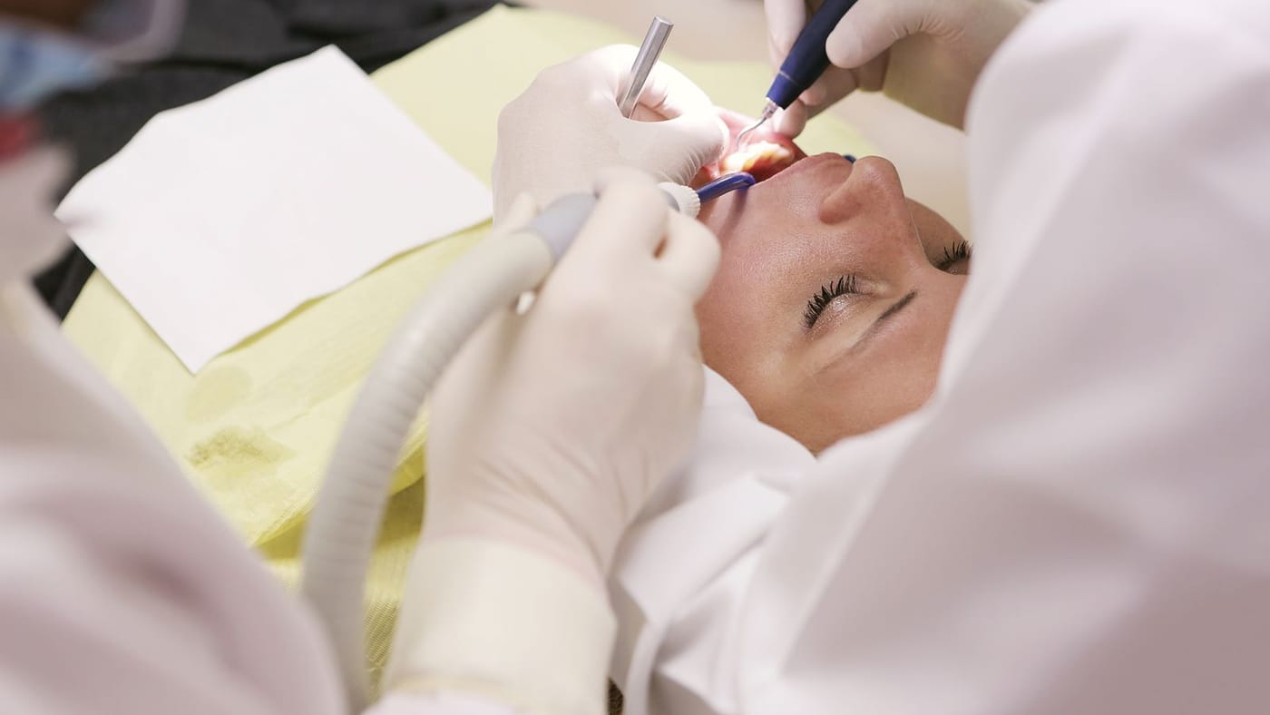 Dentista realizando procedimento odontológico
