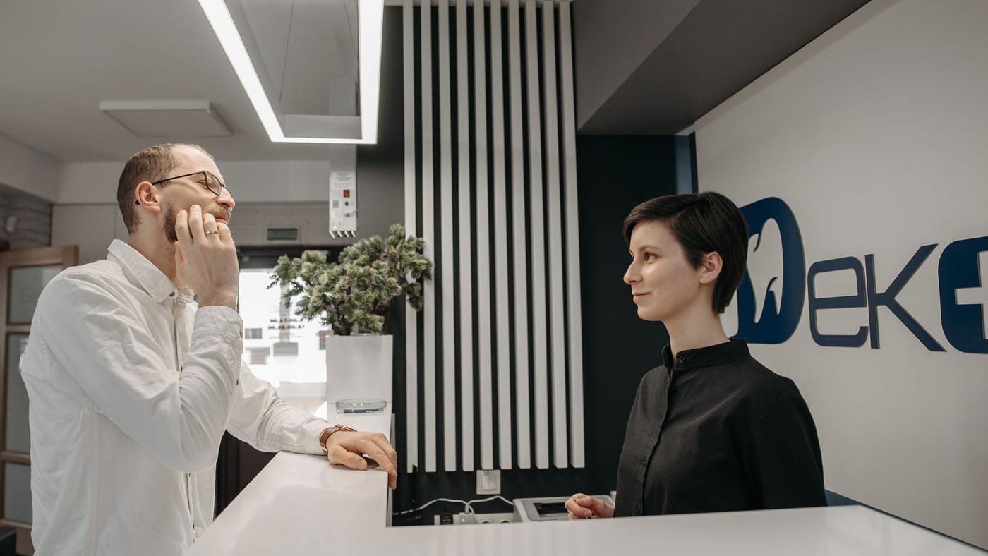Dentista e paciente conversando em um consultório odontológico