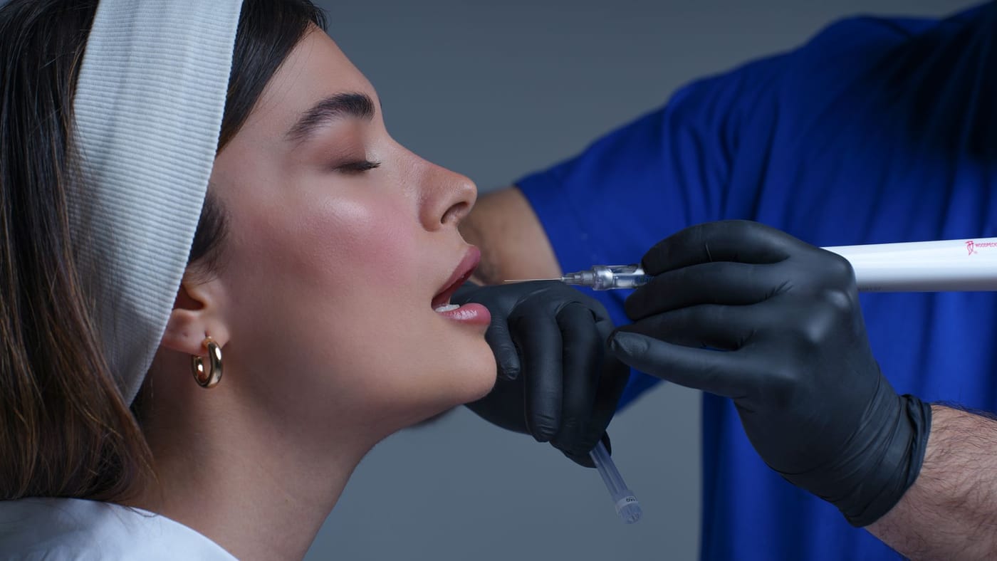 Profissional realizando um procedimento estético facial em clínica